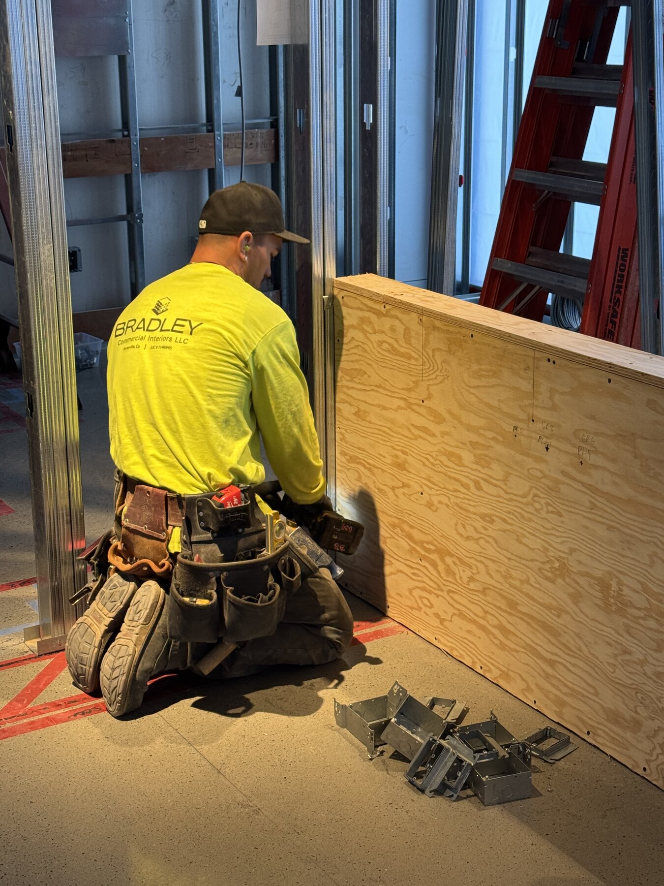 Bradley Commercial Interiors crew member installing plywood sheathing
