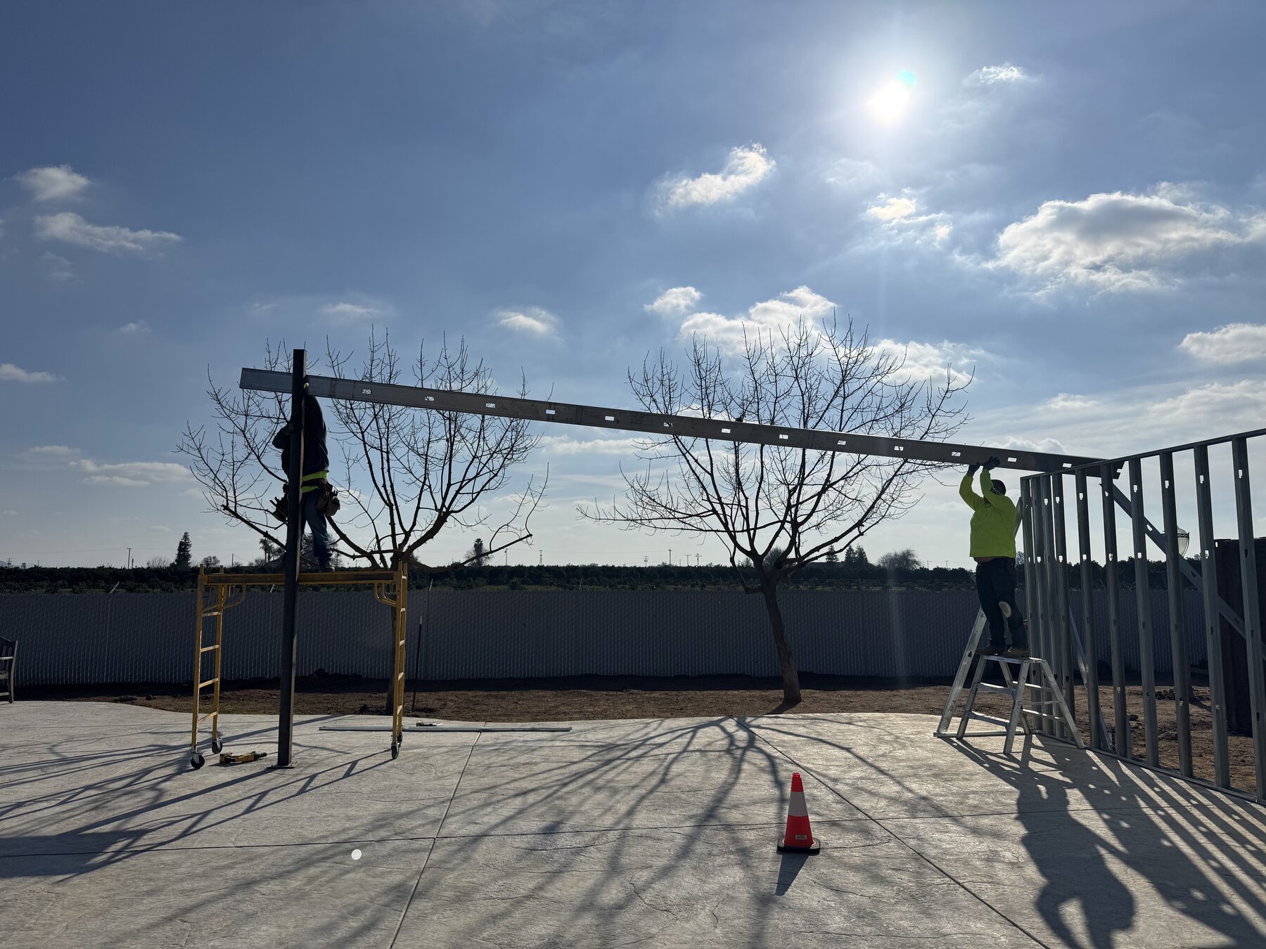 Bradley Commercial Interiors crew installing a structural beam on an outdoor patio structure